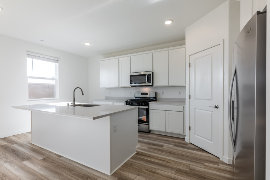 A kitchen with white cabinets.