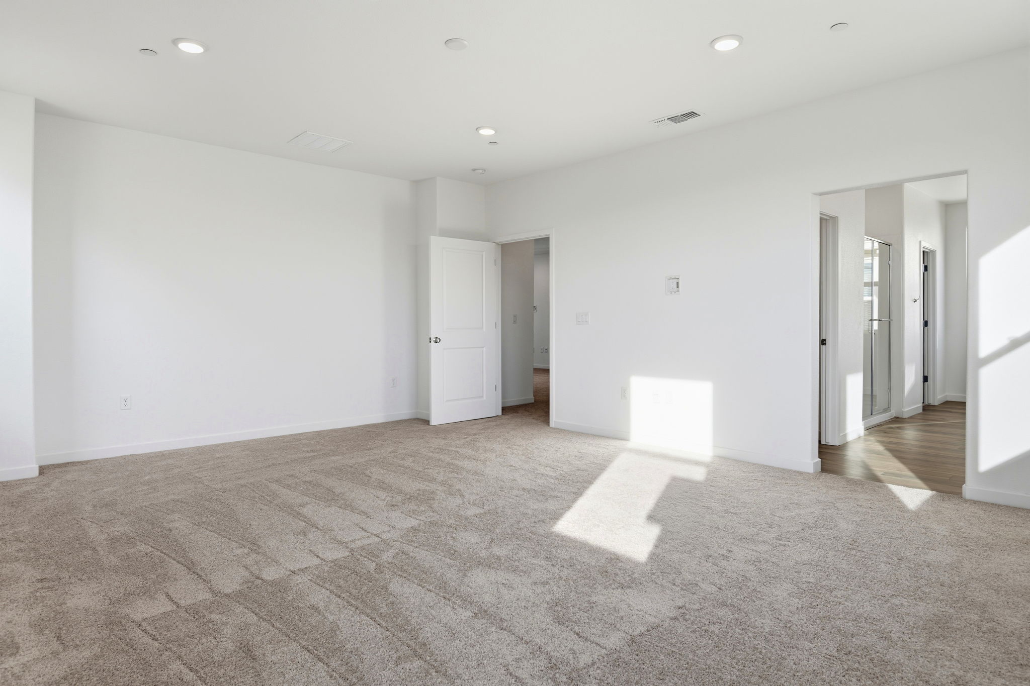 A long hallway with white doors.