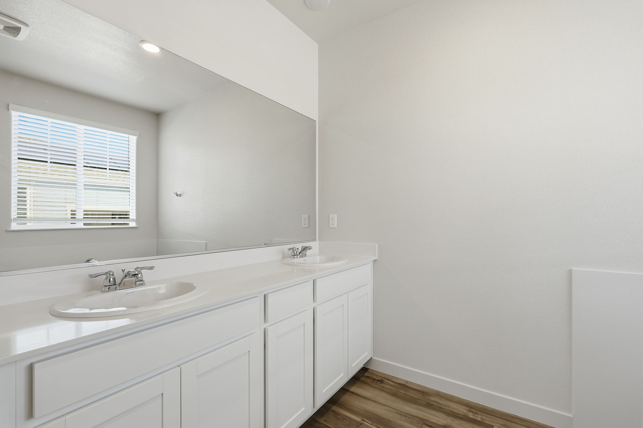 A bathroom with white cabinets.