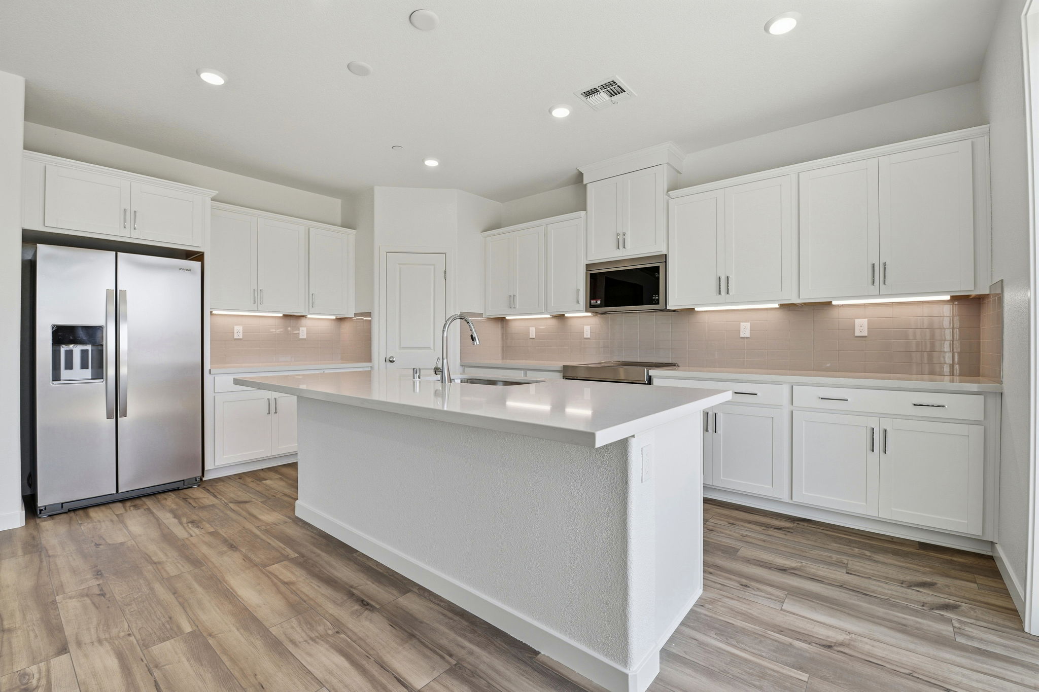 A kitchen with white cabinets.