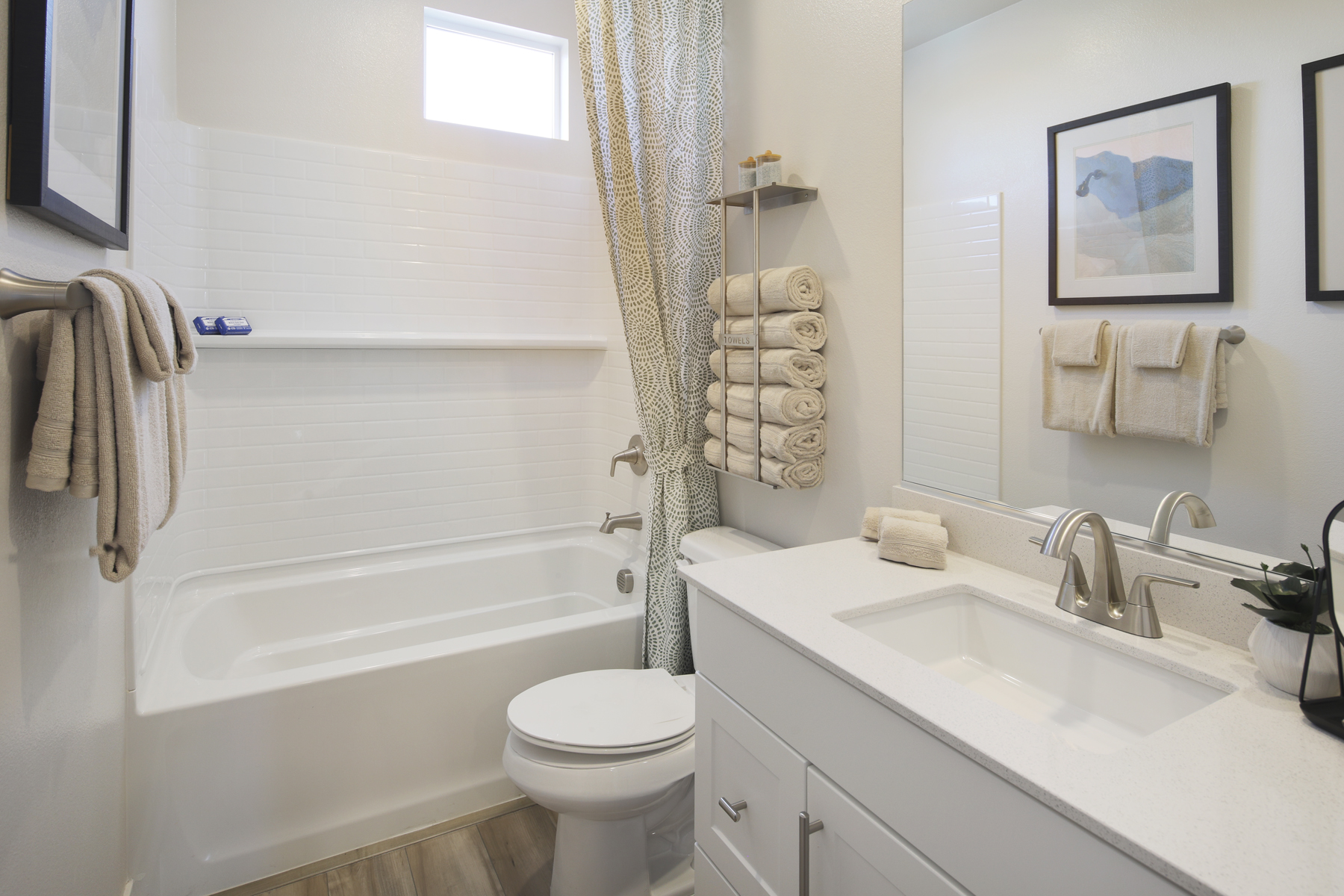 A bathroom with a sink toilet and towels.