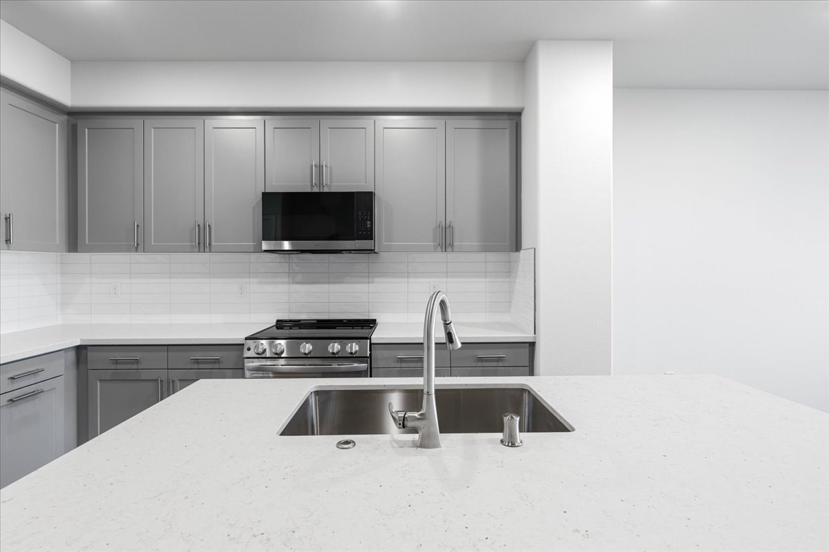 A kitchen with white cabinets.