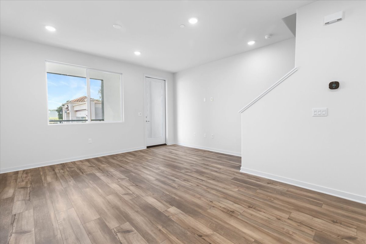 A room with a wood floor and a window.