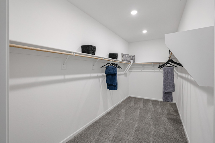 A white bathroom with a grey rug and a grey rug.