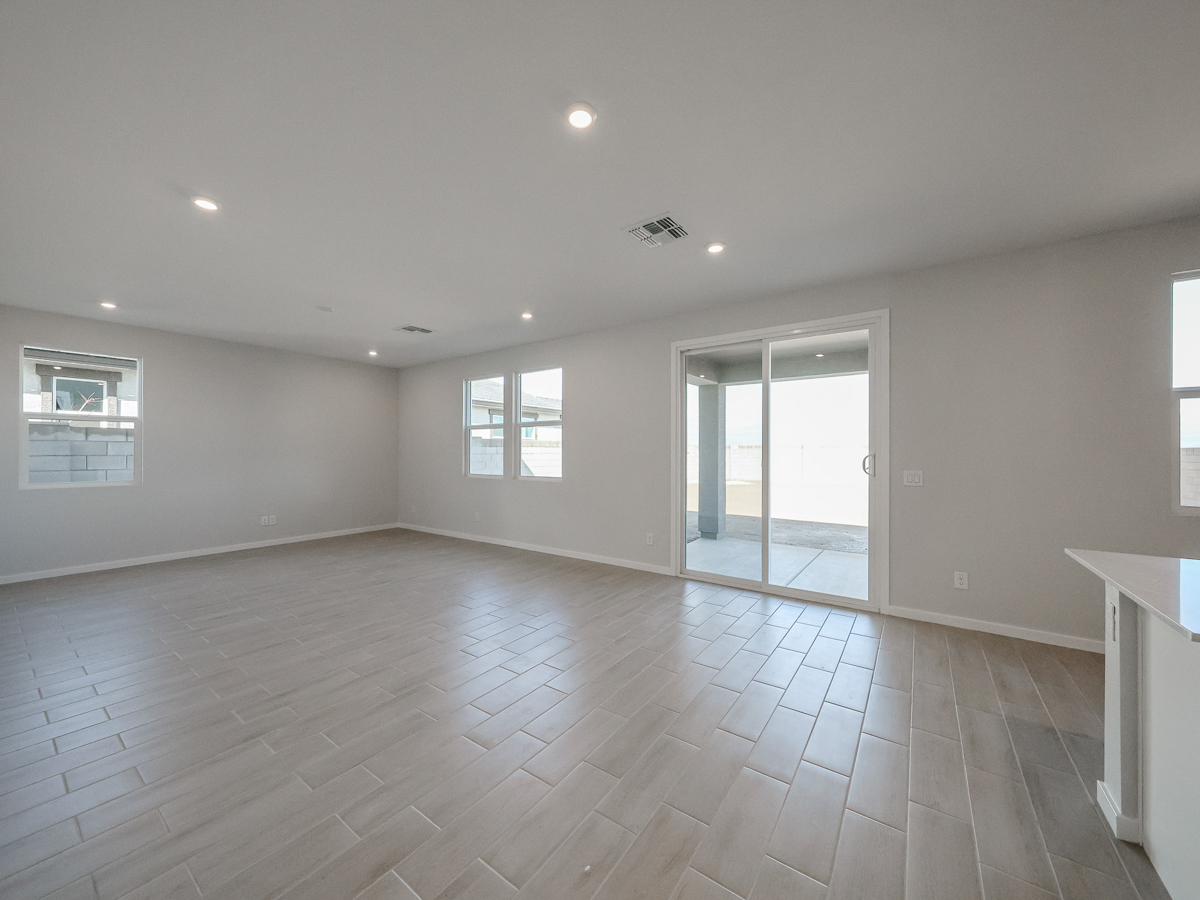 A large empty room with a wood floor and white walls.