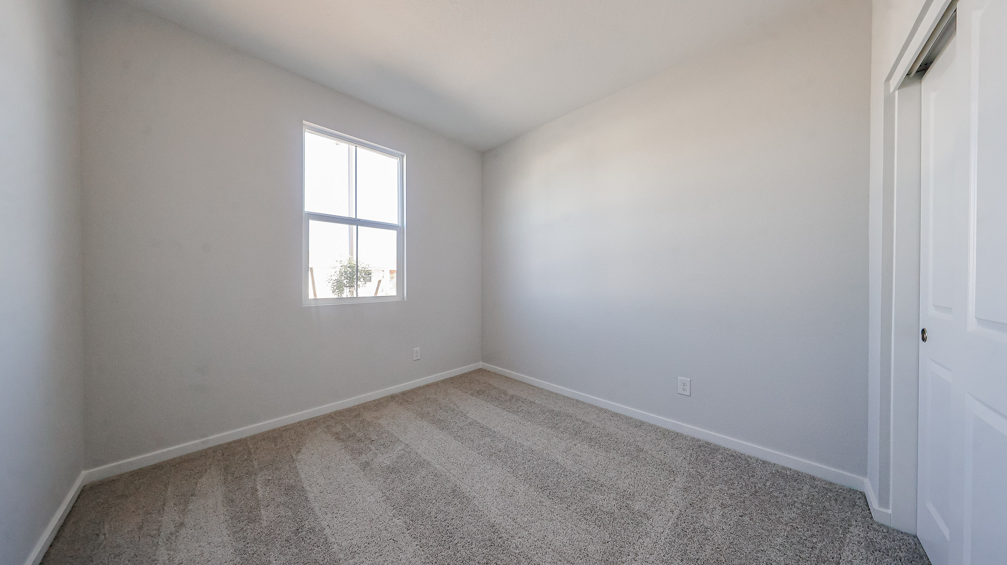 A room with a window and carpet.