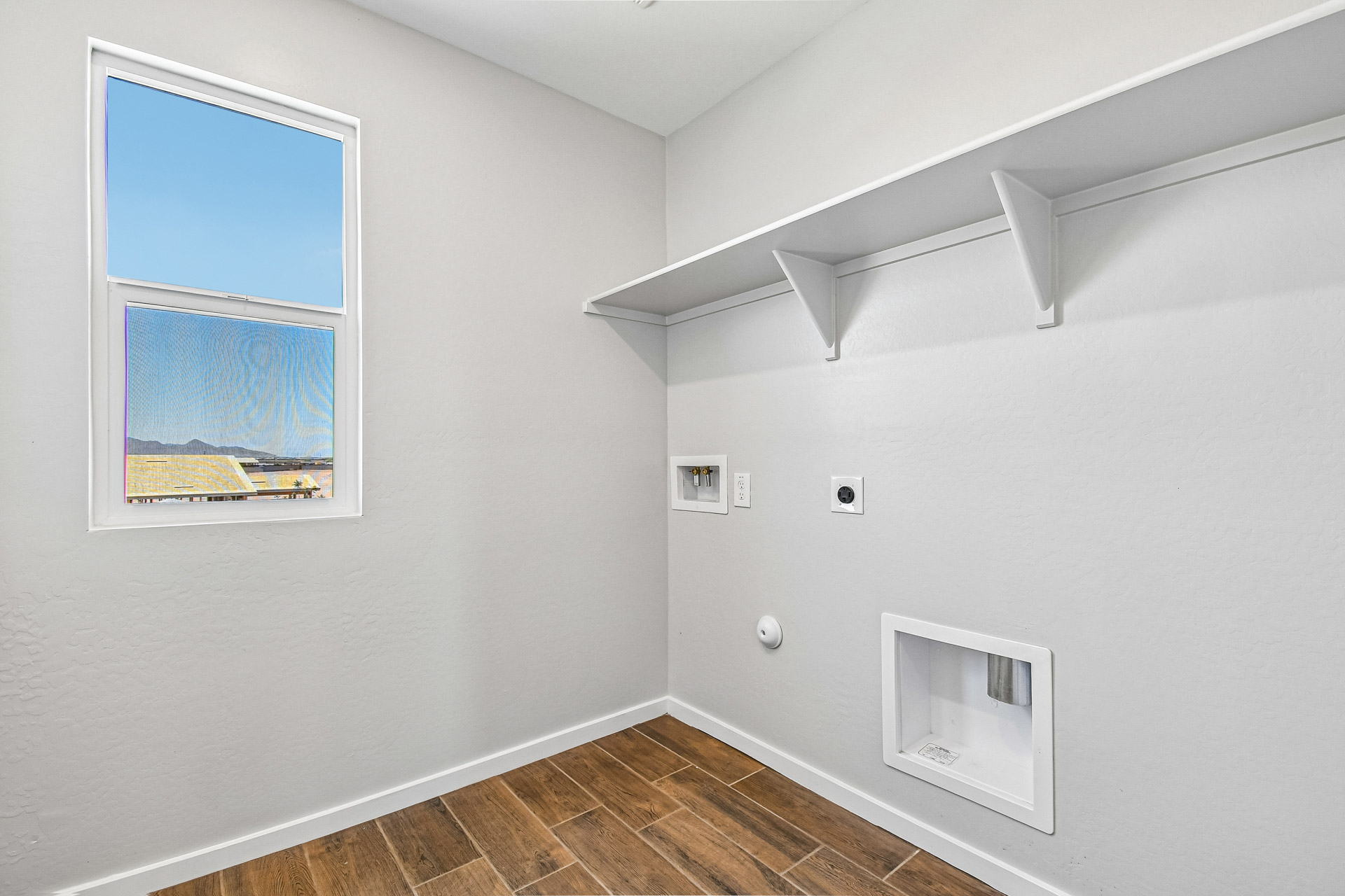 A room with a window and a painting on the wall.