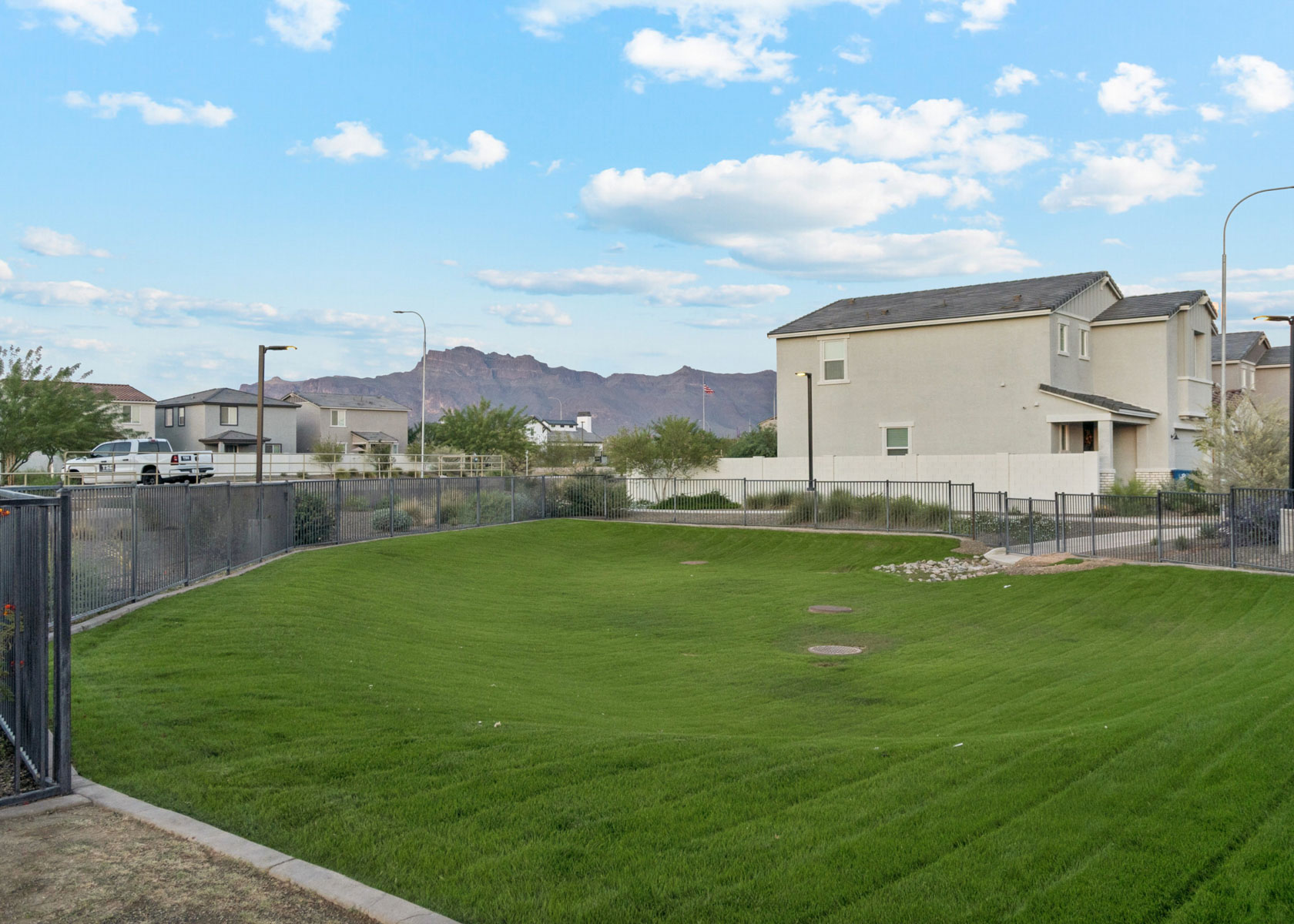 A grassy area with buildings in the background.