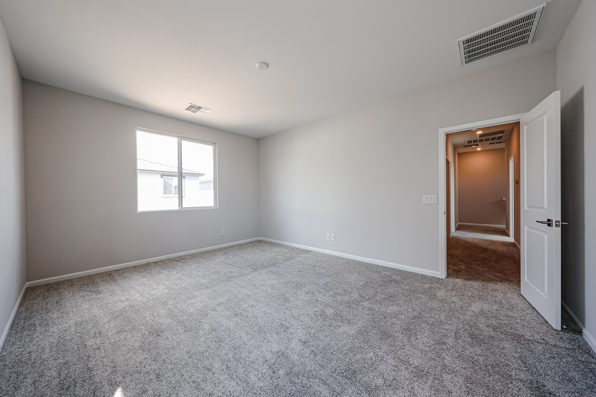 A room with a carpet and a door.