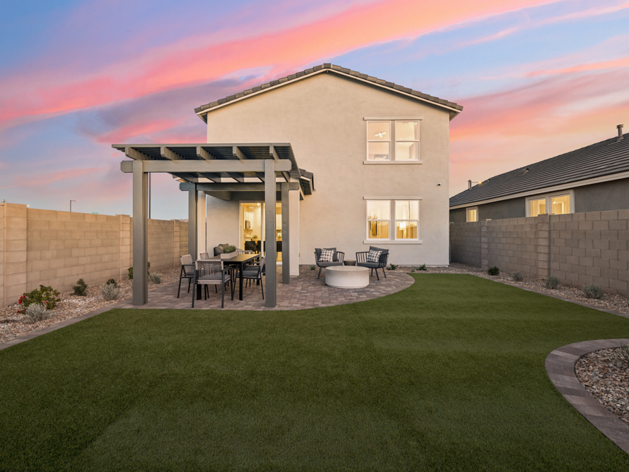 A house with a patio and a table and chairs in the front.