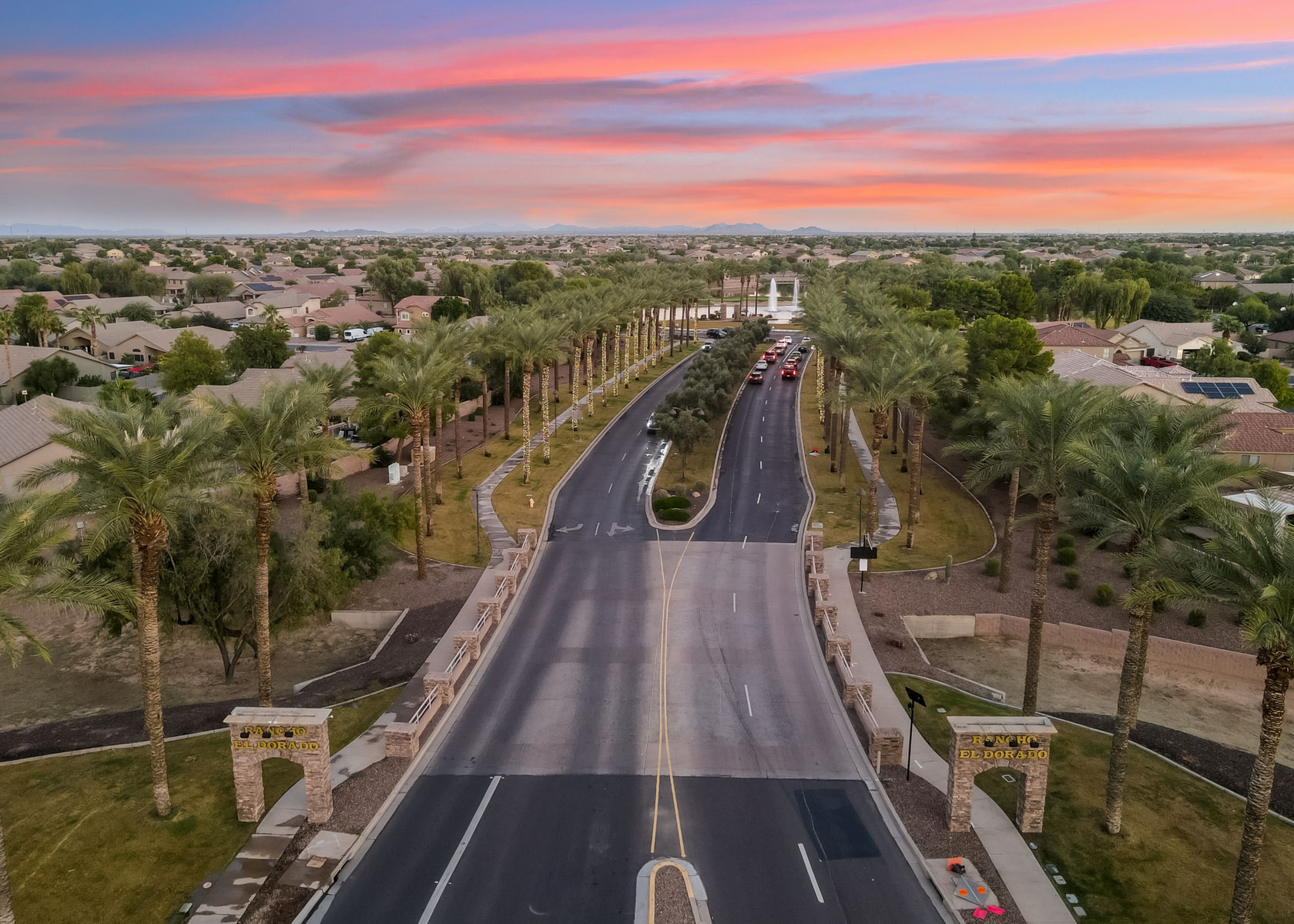 A road with cars on it and trees on the side.