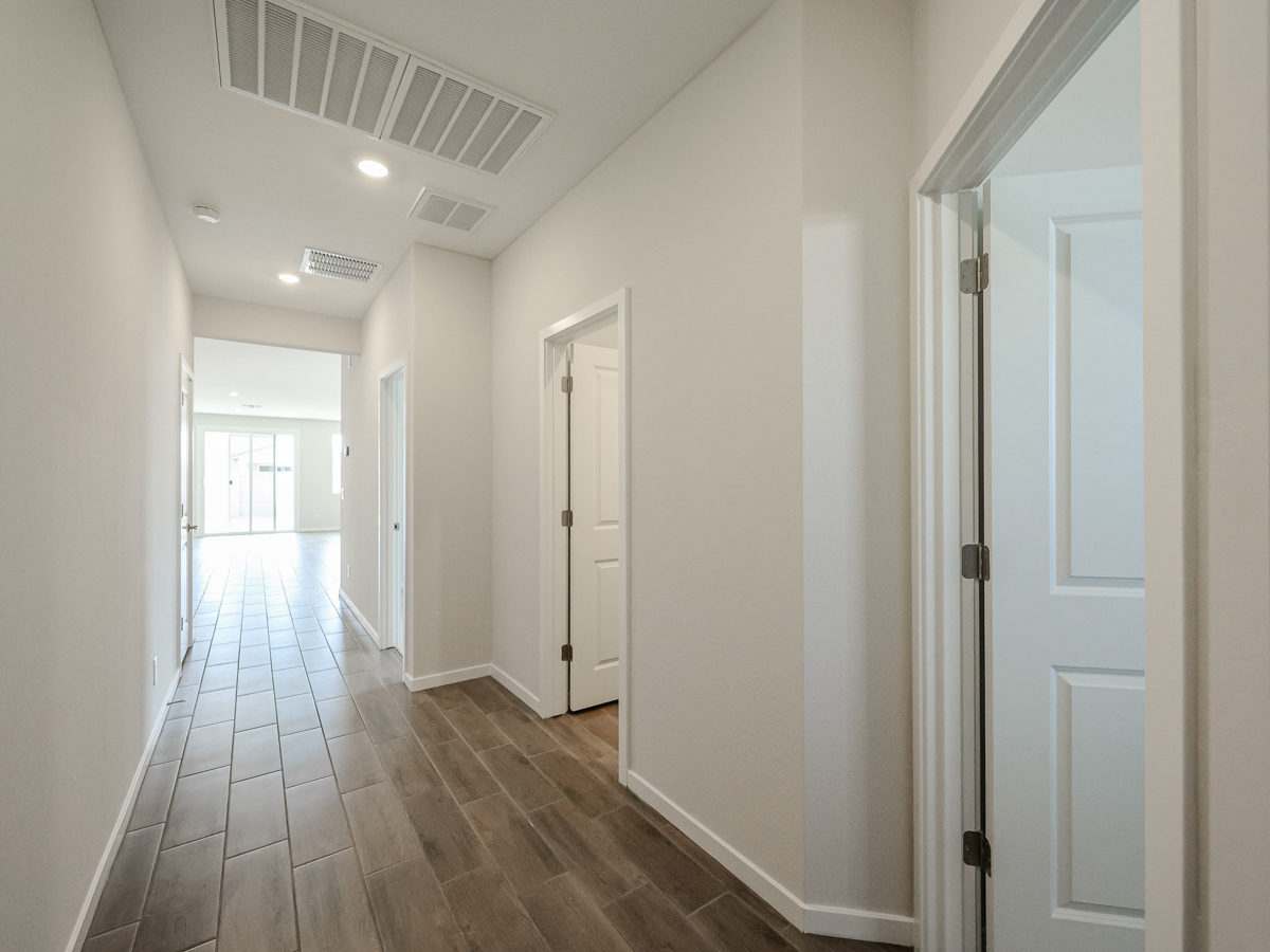 A long hallway with white doors.