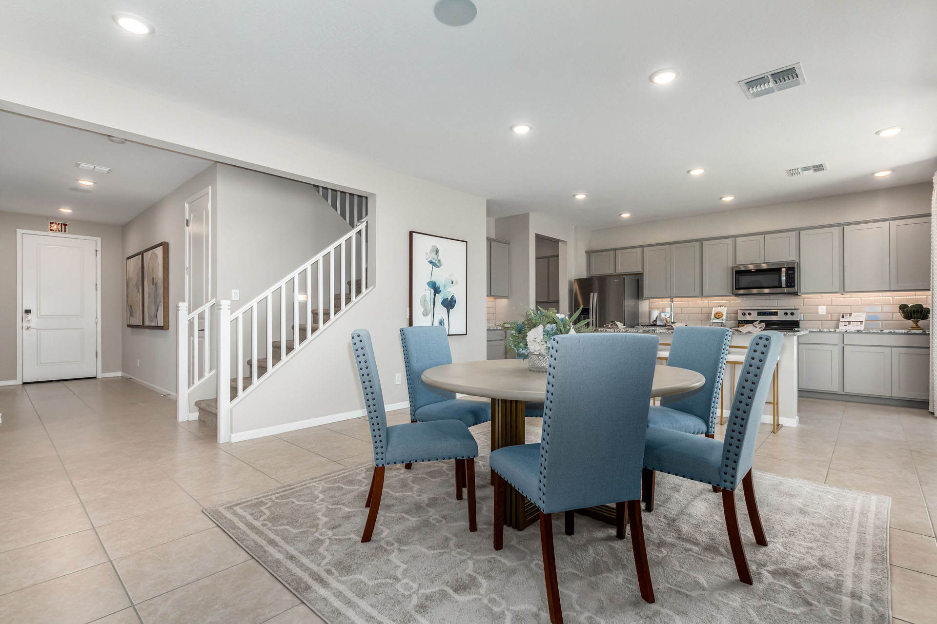 A kitchen with a dining table and chairs.