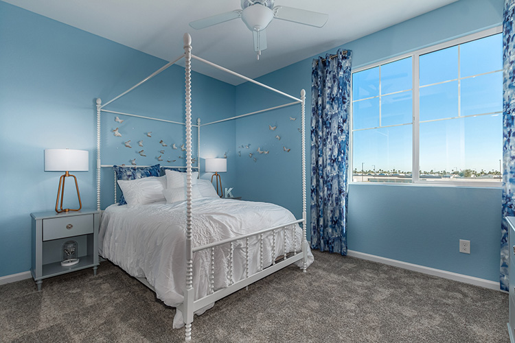 A bedroom with a bed and a fan.