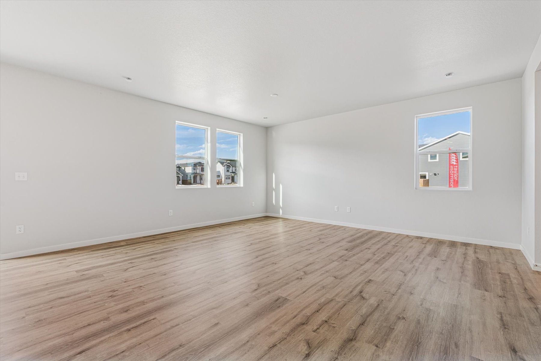 A room with a wood floor and a wood floor with a window.