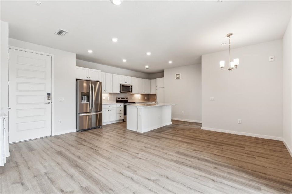 A kitchen with white cabinets.