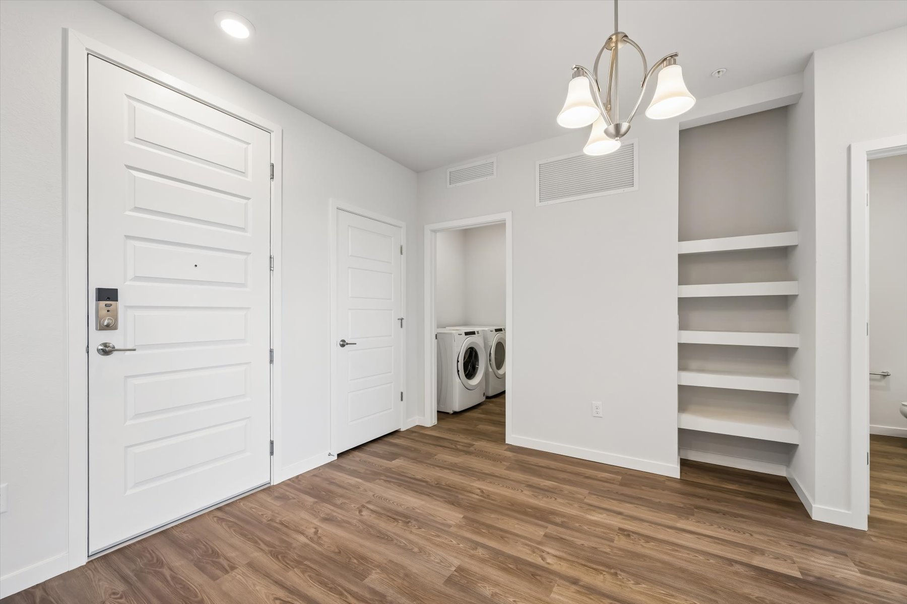 A room with white cabinets and a white door.