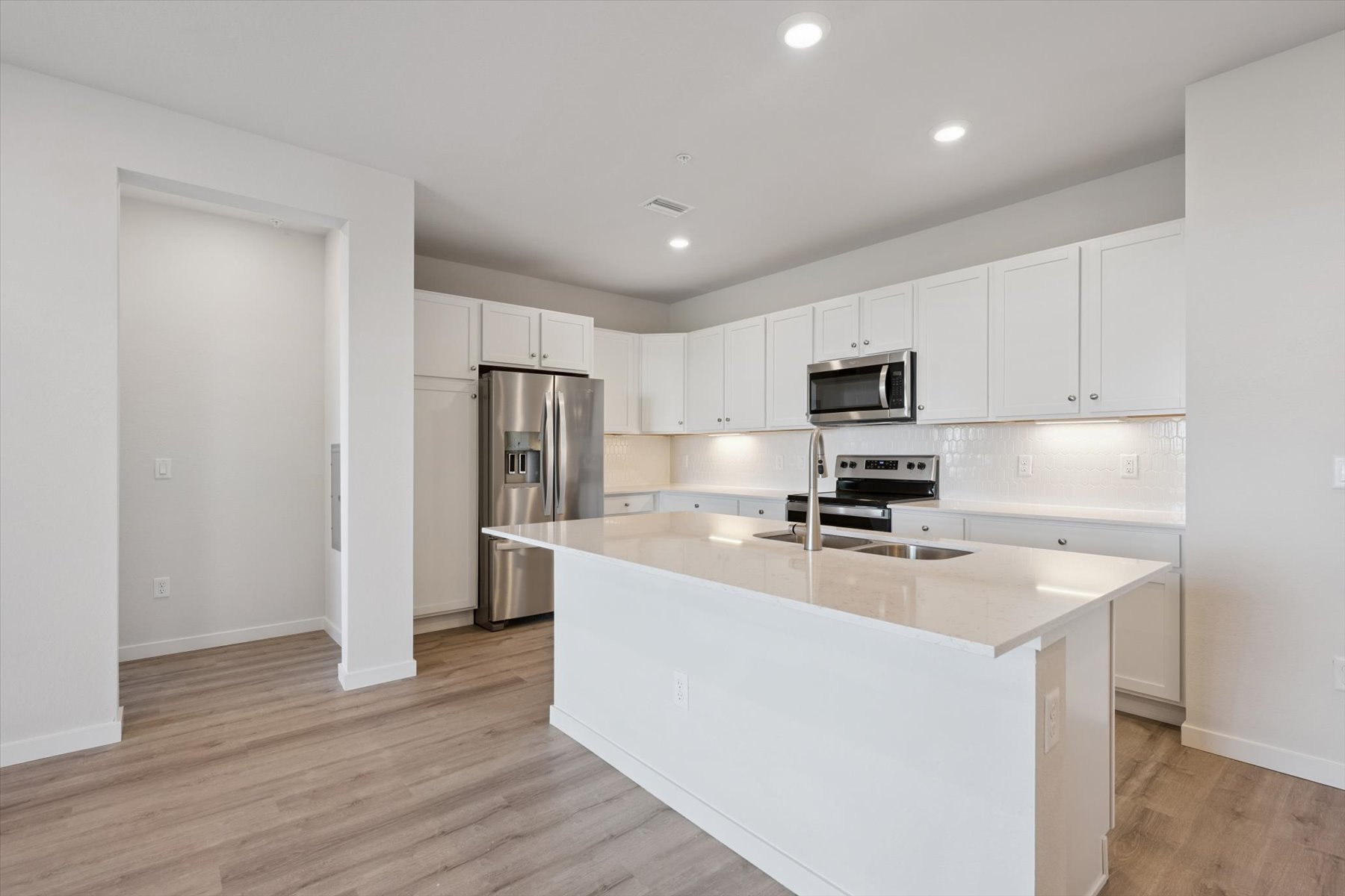 A kitchen with white cabinets.