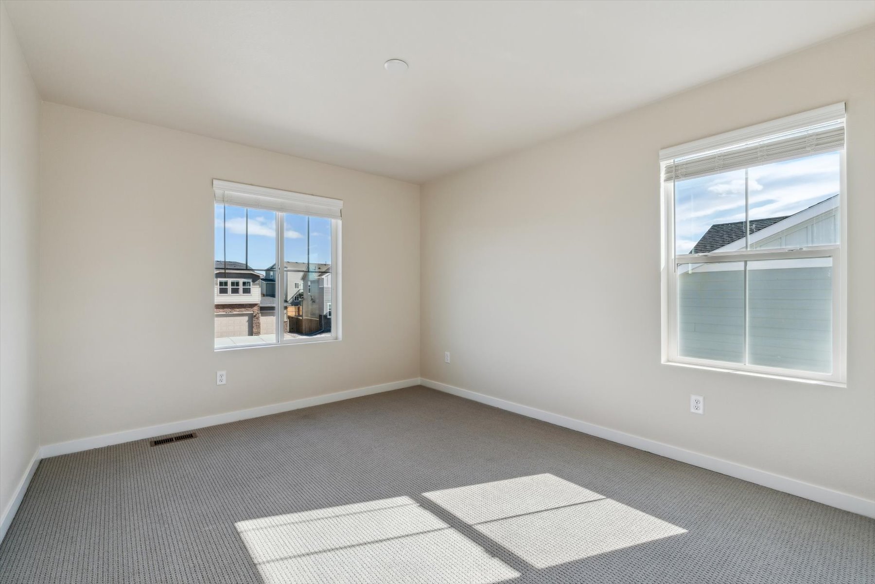 A room with windows and a rug.