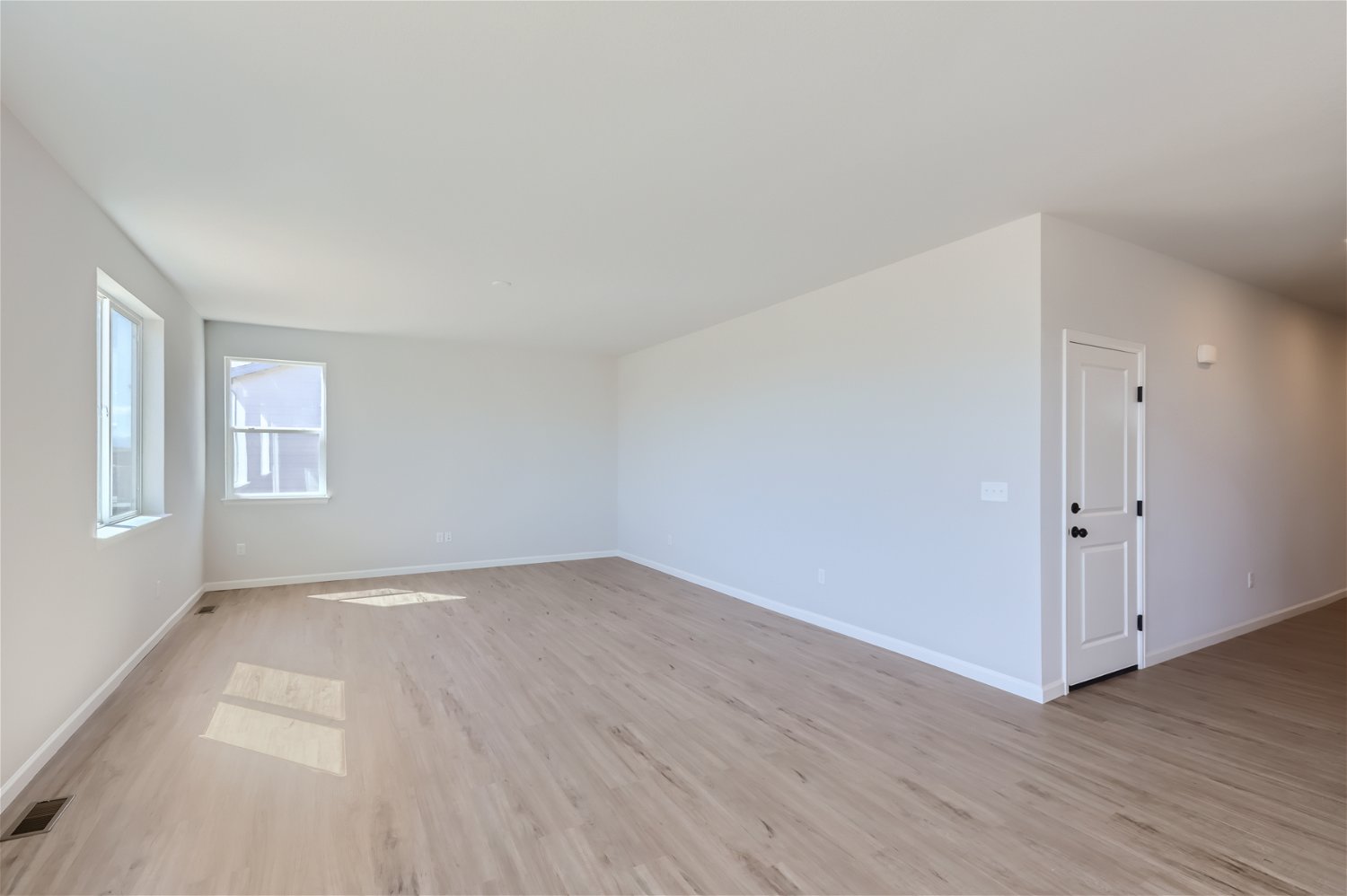 A room with a wood floor and white walls.