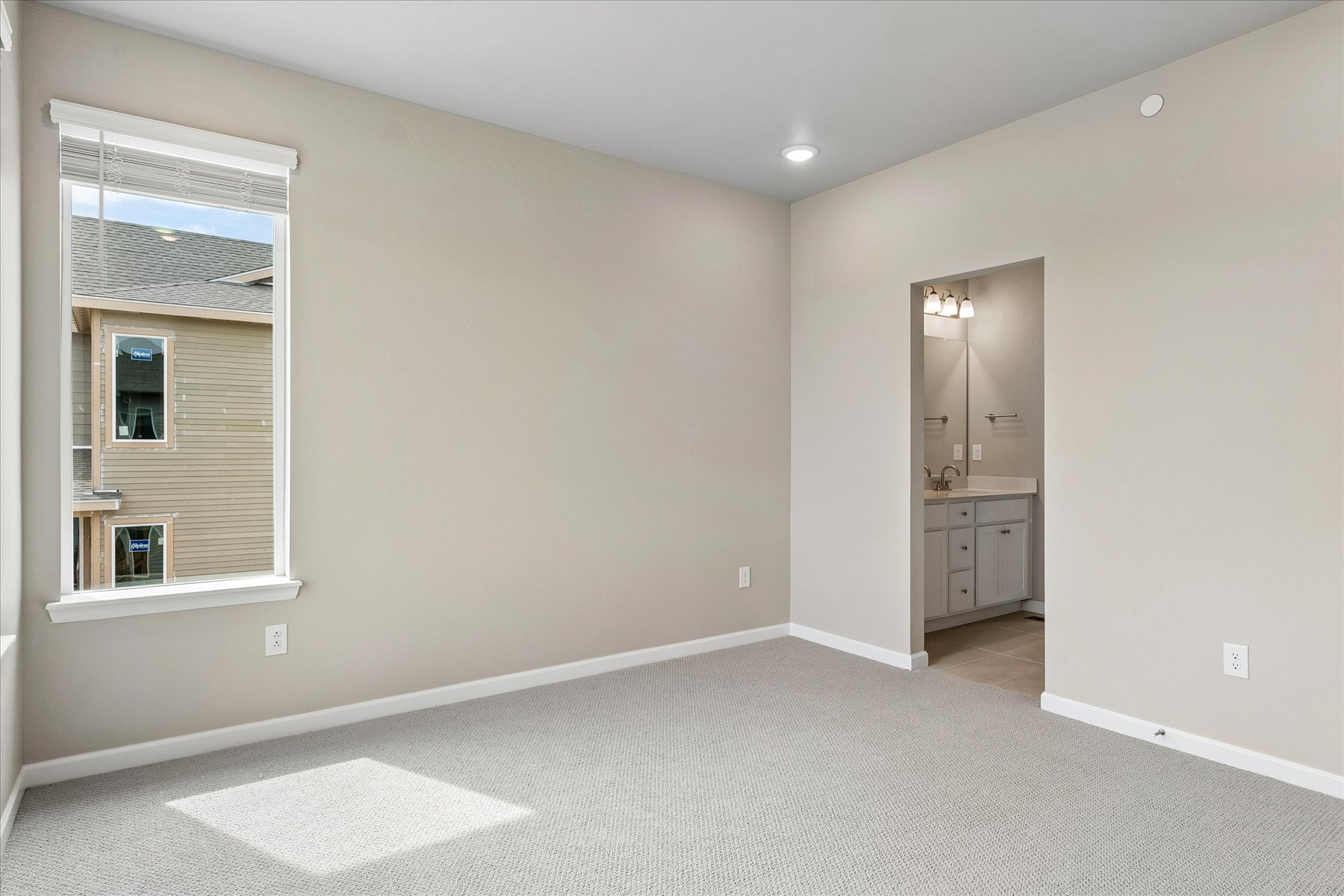 A room with a white carpet and a window.