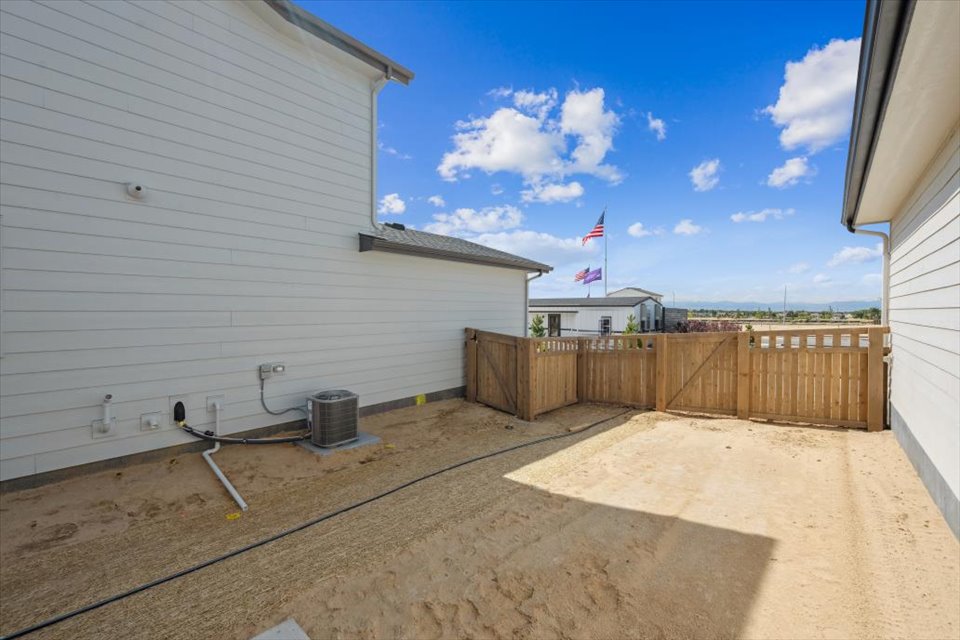 A fenced off area with a wood fence and a building in the background.