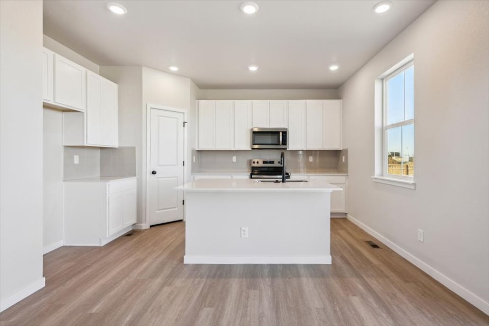 A kitchen with white cabinets.