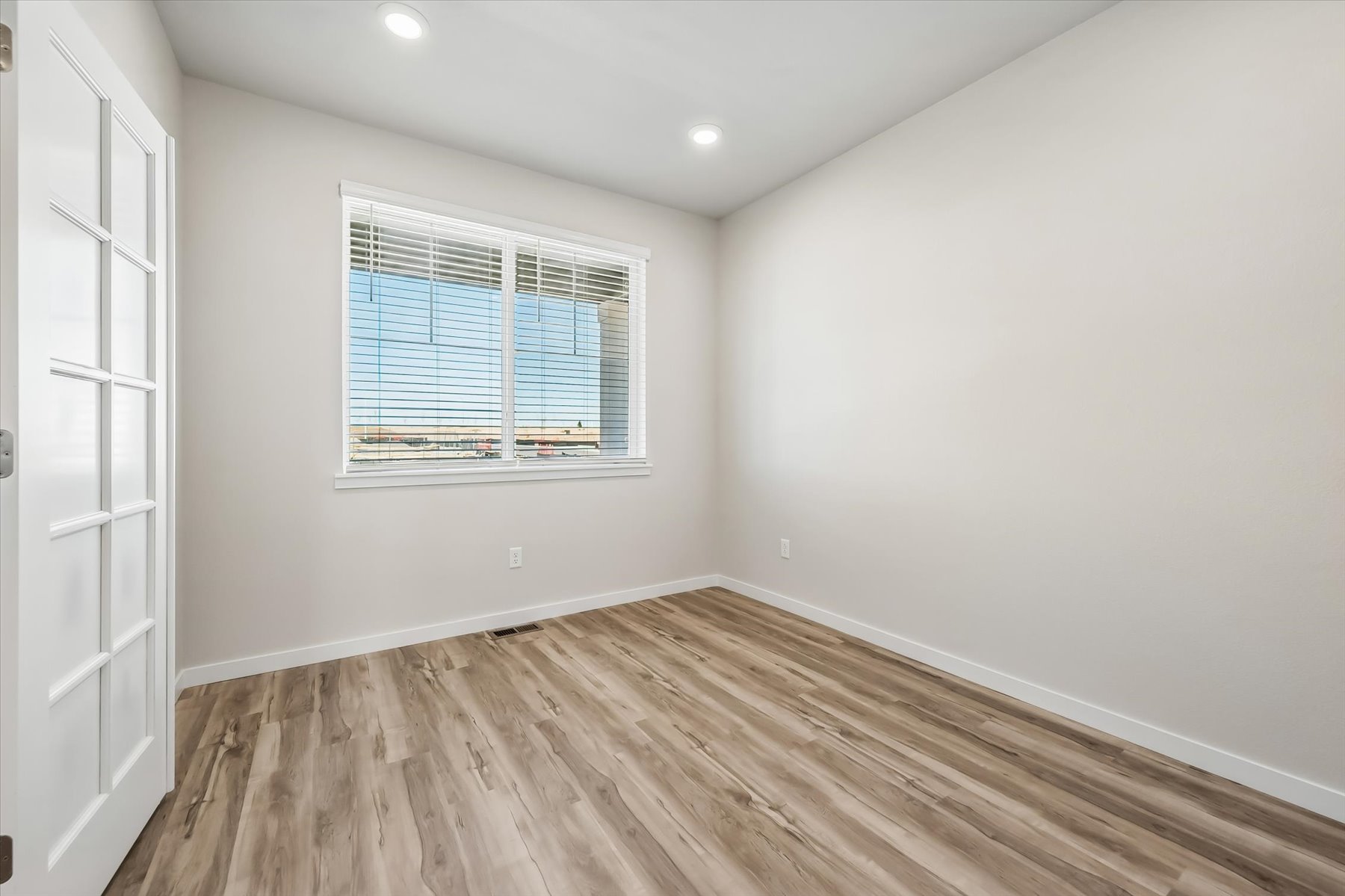 A room with a wood floor and a window.
