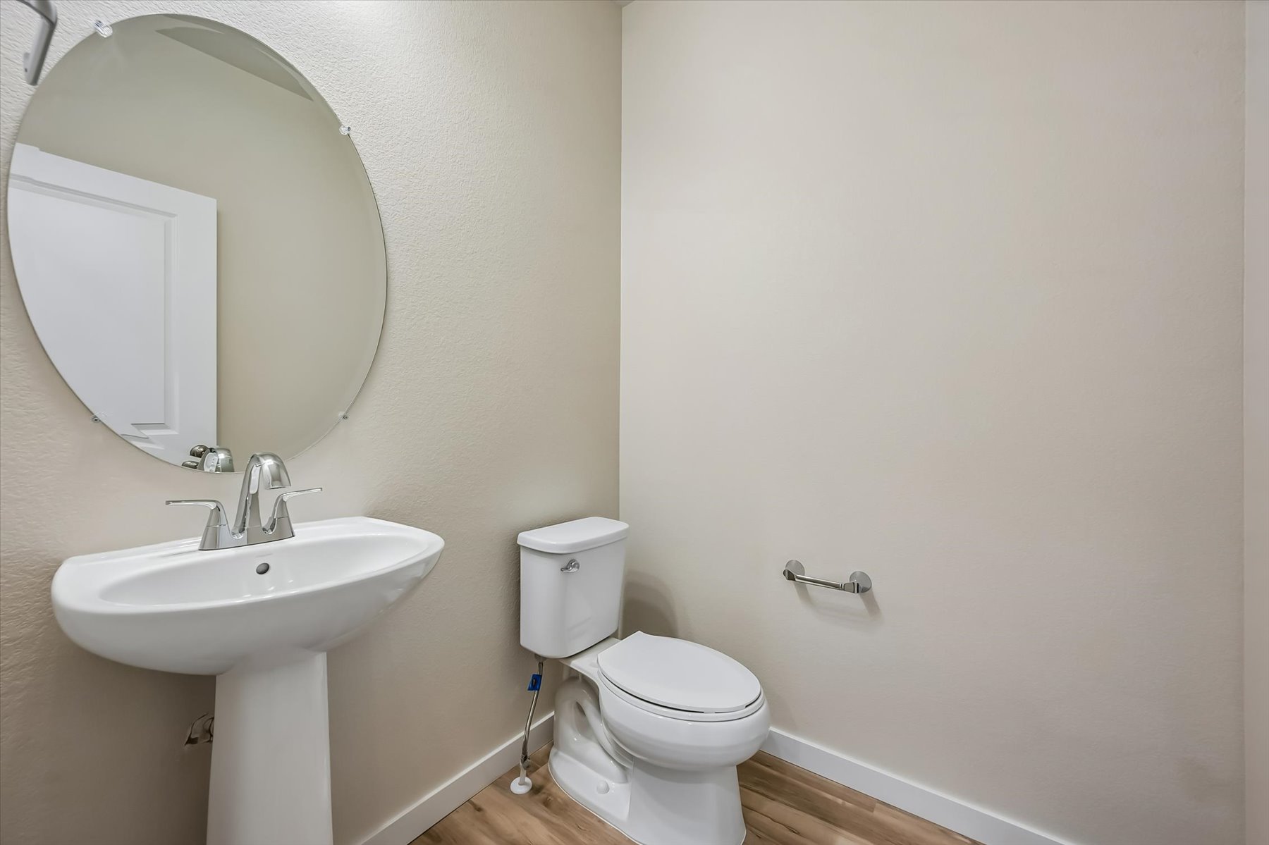 A bathroom with a round mirror.