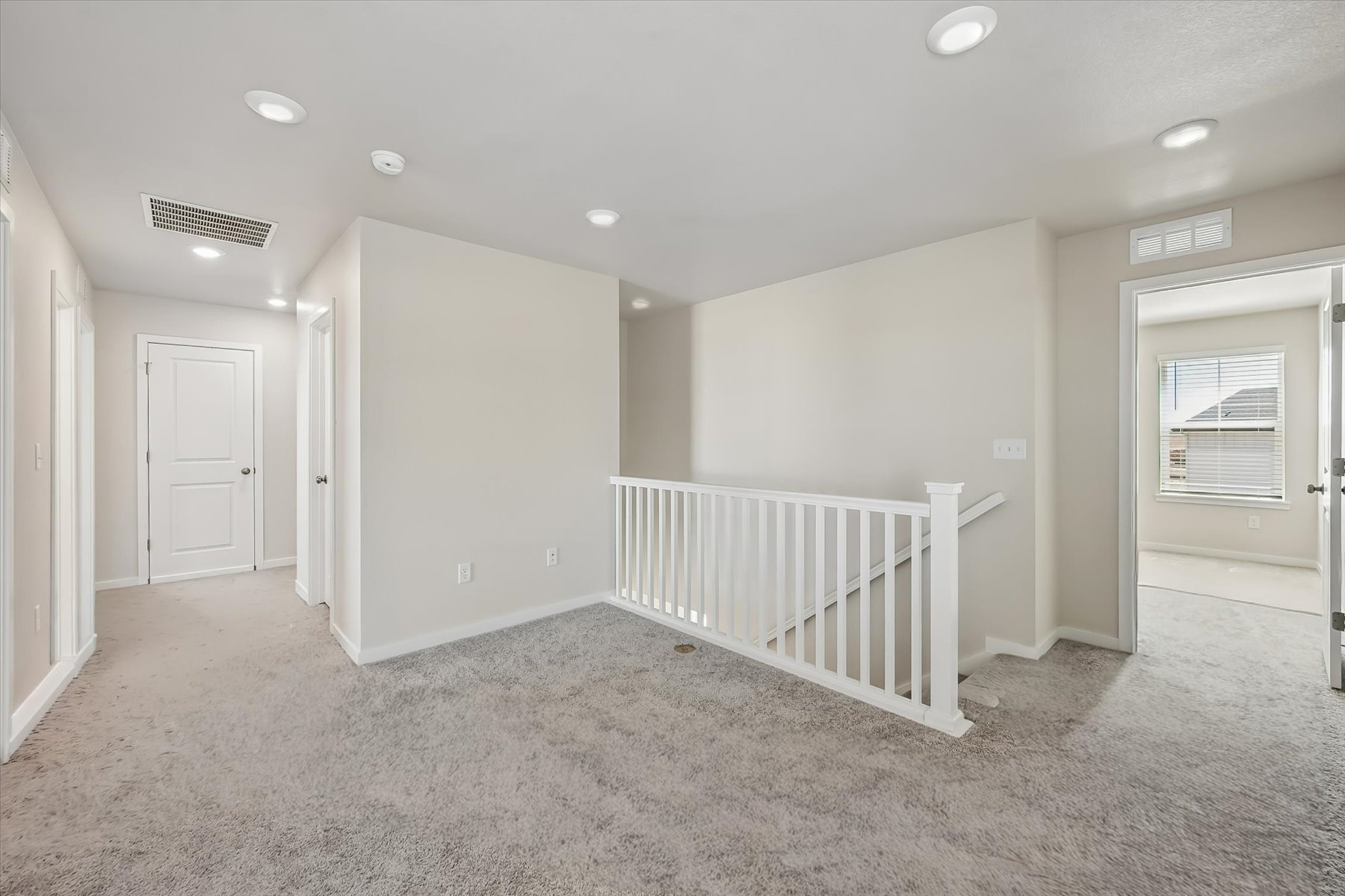 A room with white walls and a white railing.