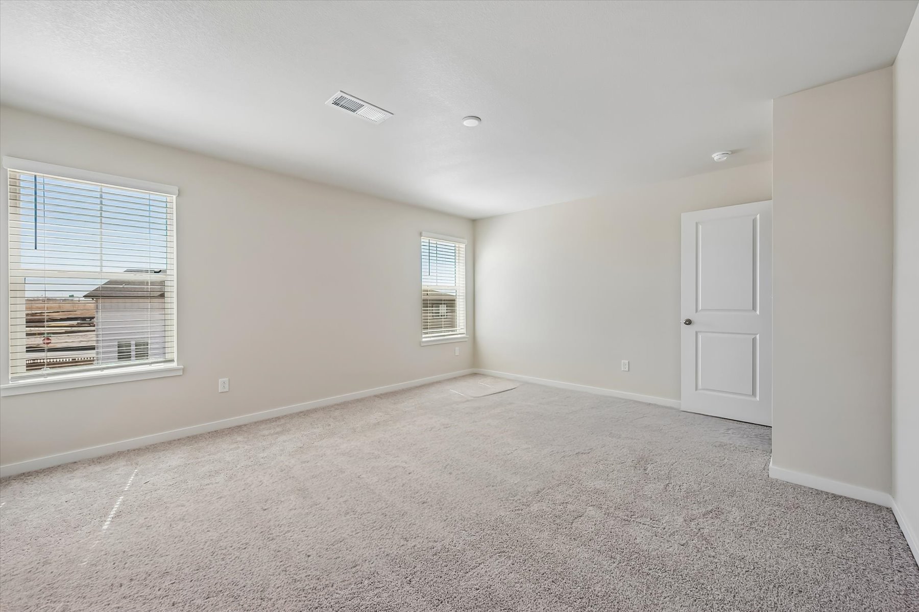 A room with a carpet and windows.