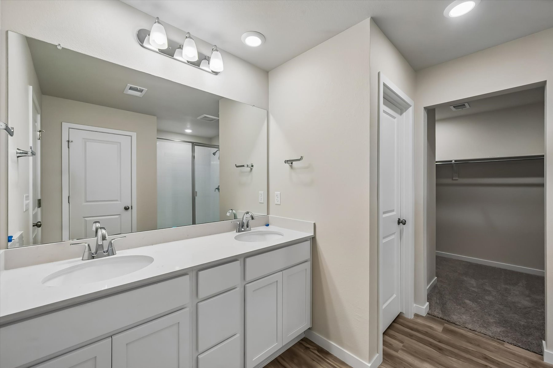 A bathroom with a sink and a shower unit.