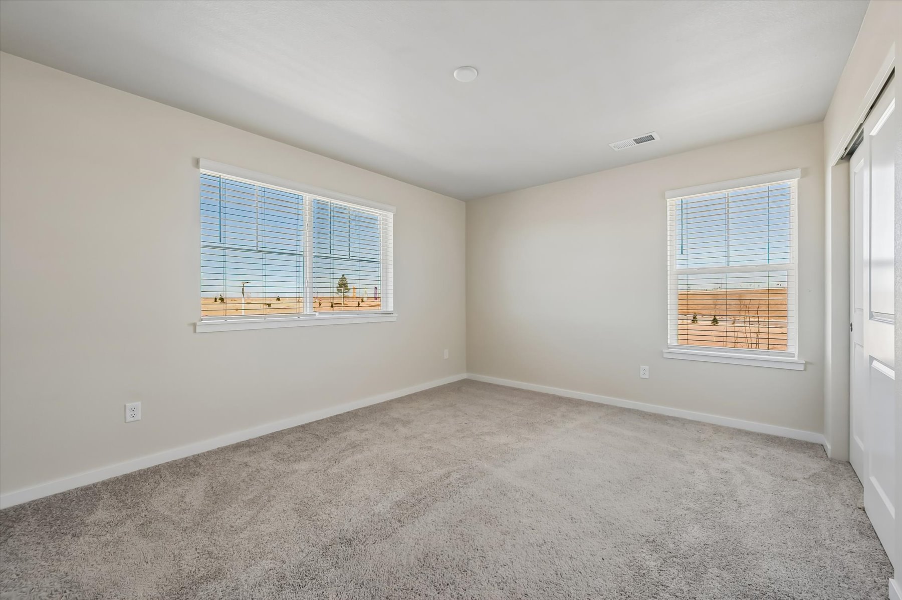A room with windows and a carpet.