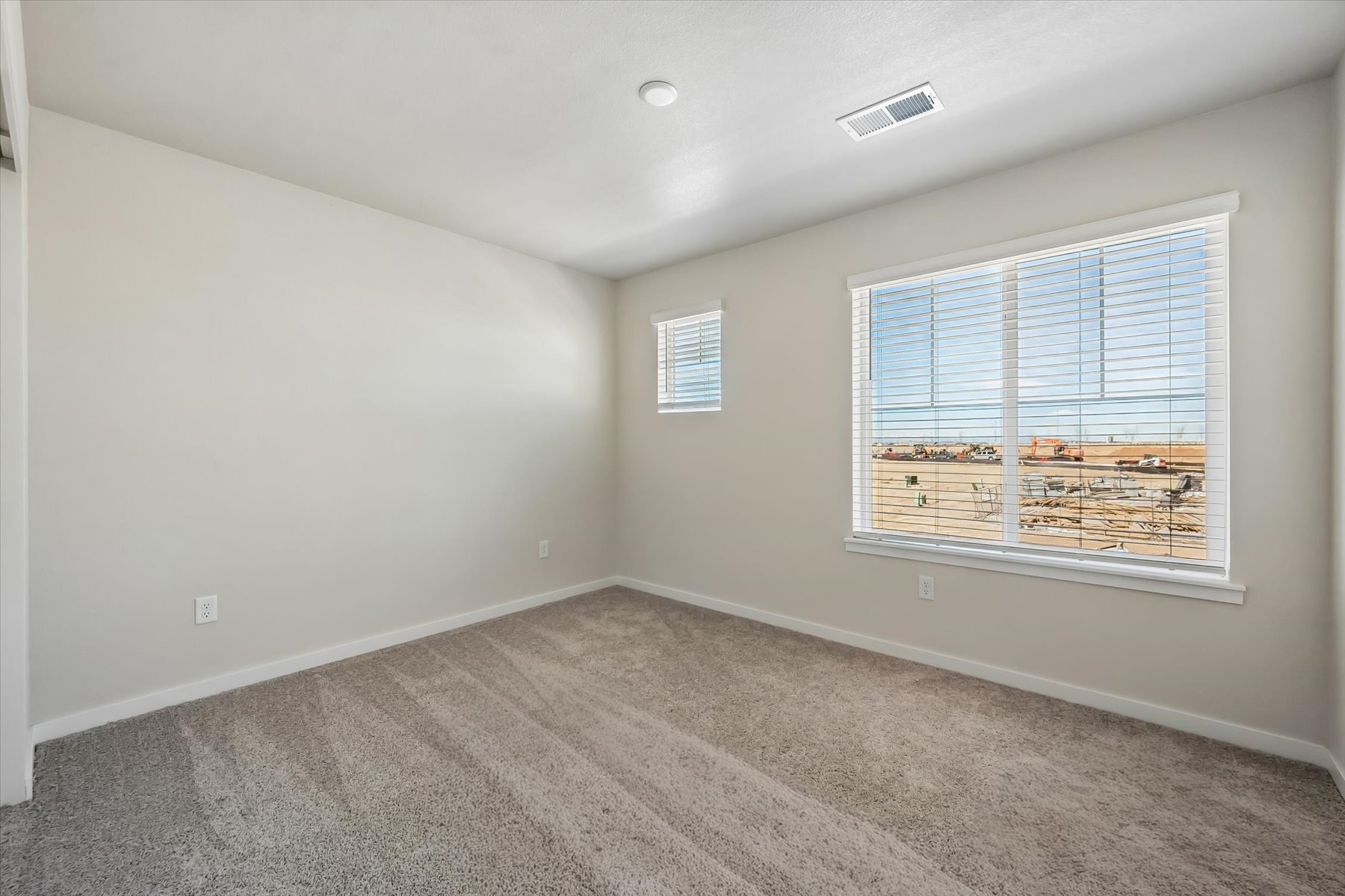 A room with a window and a carpet.