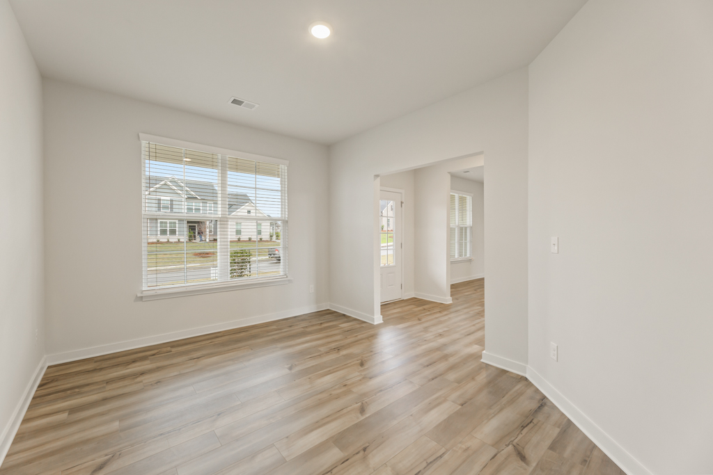 A room with a wood floor and a window.