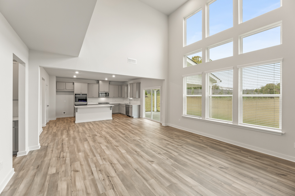 A large empty room with a wood floor and a large window.