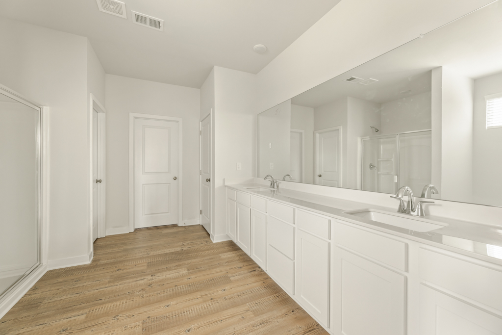 A bathroom with white cabinets.