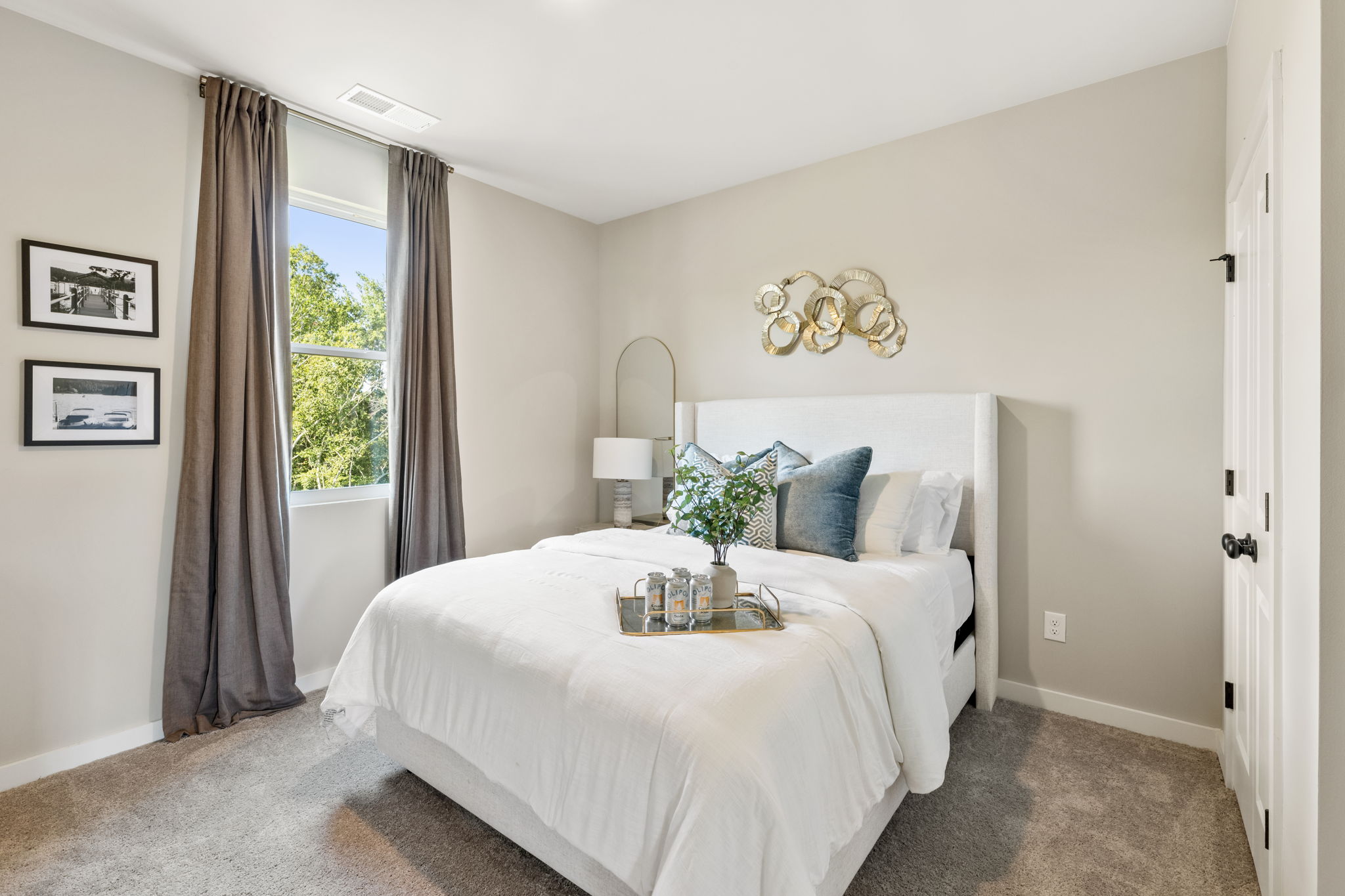 A bedroom with a bed and a mirror.