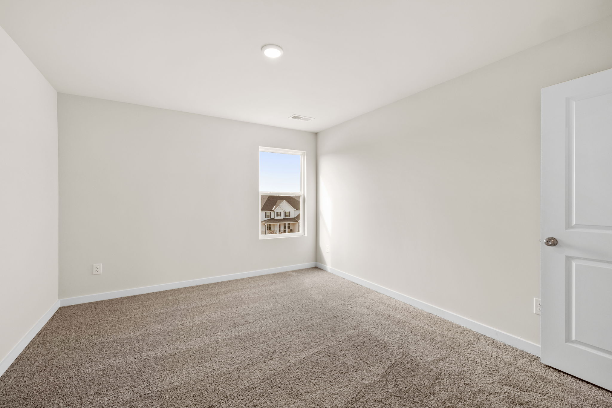 A room with a carpet and a door.