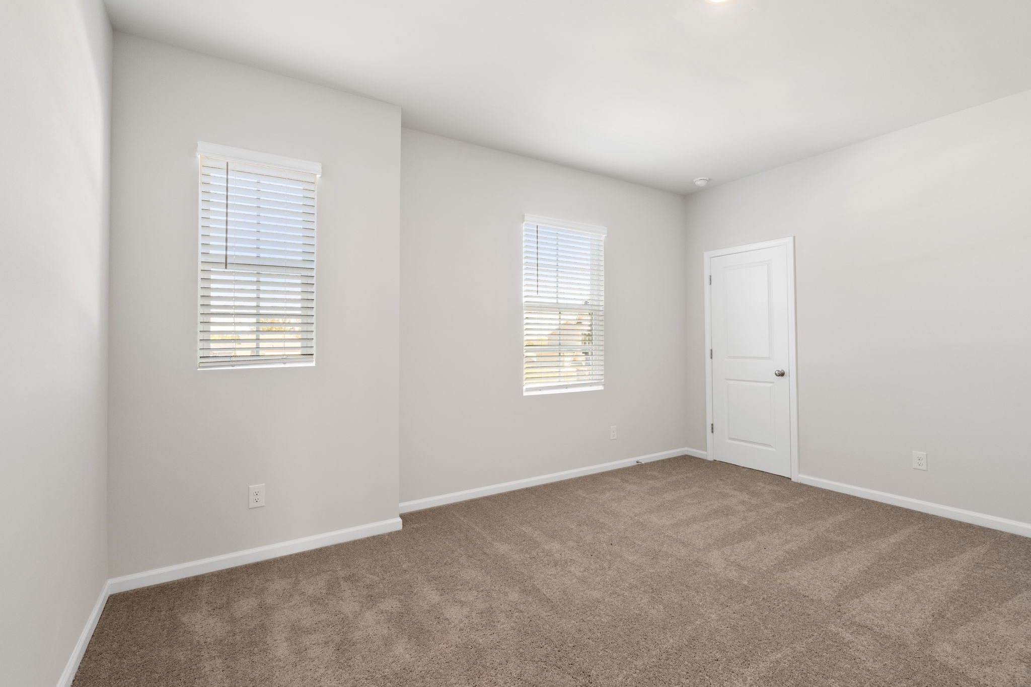 A room with a carpet and a door.