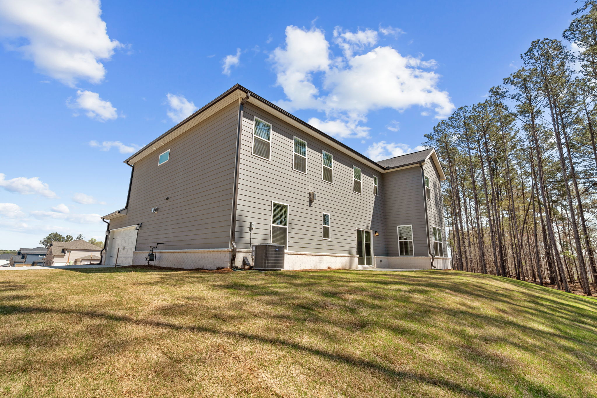 A house with trees in the back with Rockingham Meeting House in the background.