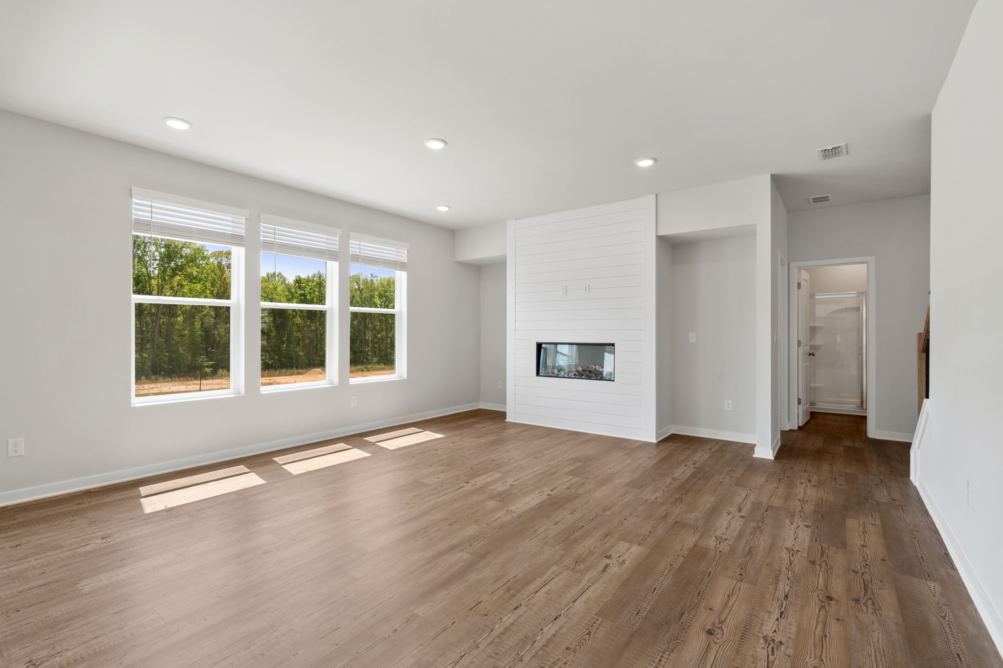 A room with a wood floor and a fireplace.