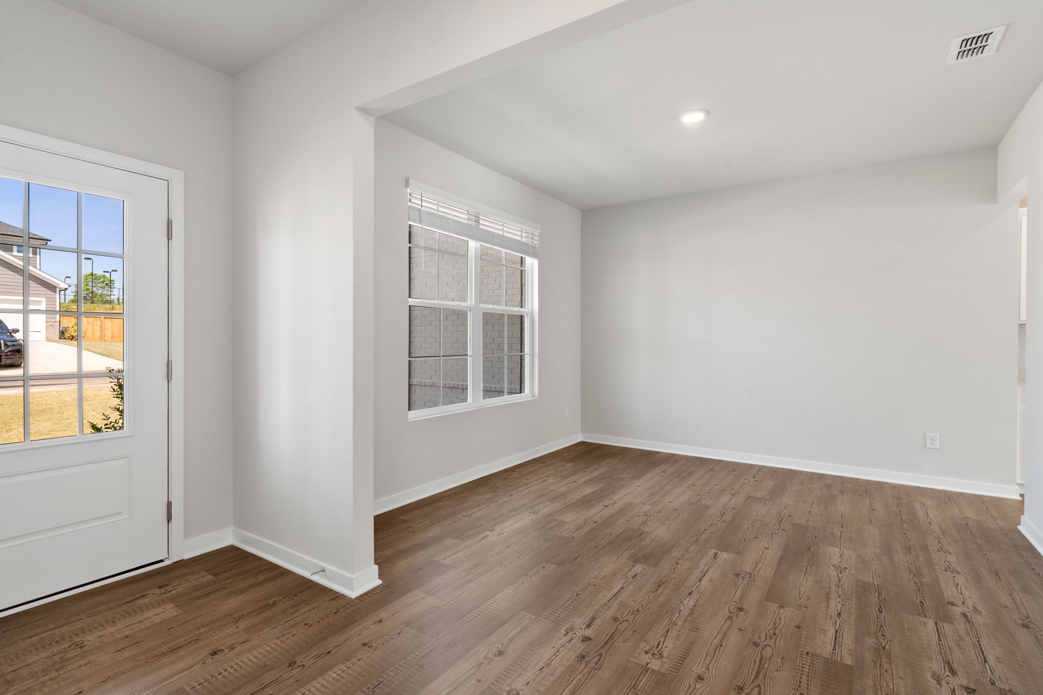 A room with a wood floor and windows.