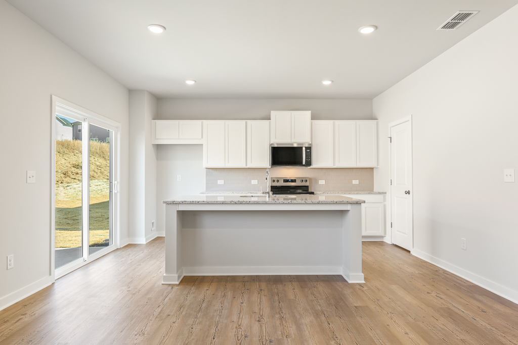 A kitchen with white cabinets.