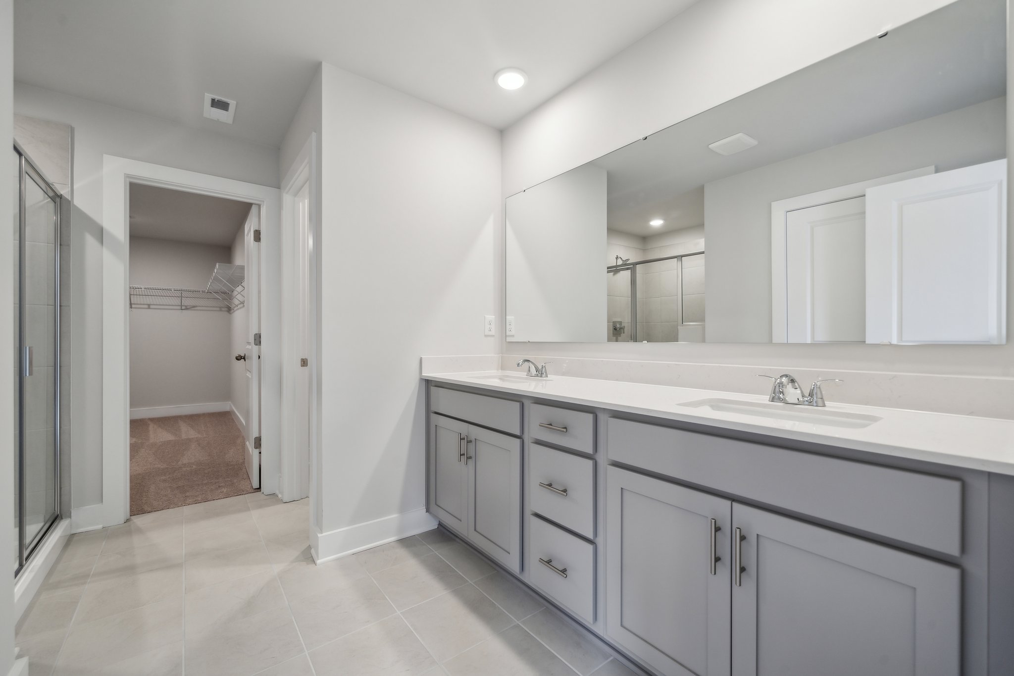 A bathroom with white cabinets.
