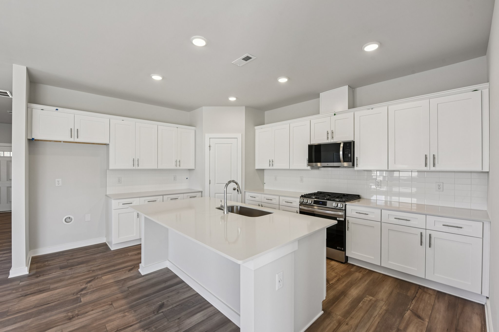 A kitchen with white cabinets.