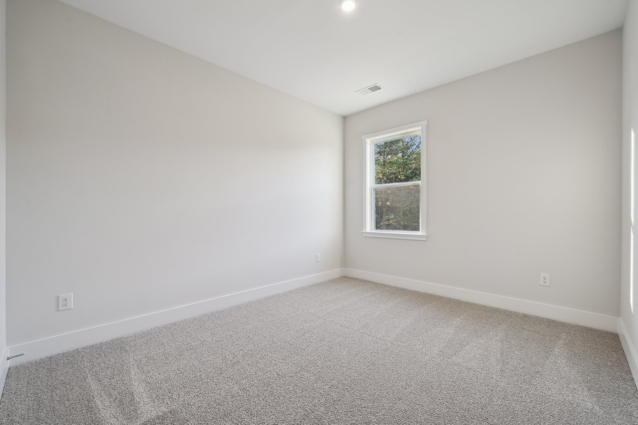 A room with a window and carpet.