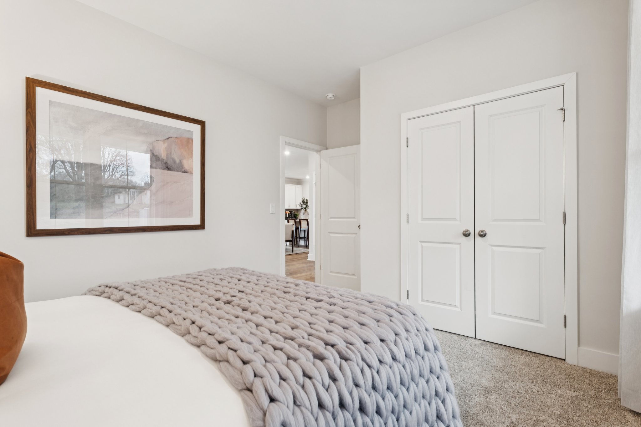 A bedroom with a bed and a painting on the wall.
