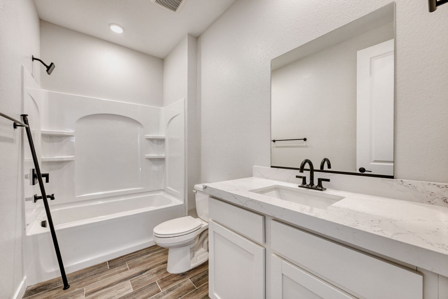 A bathroom with a tub sink and toilet.