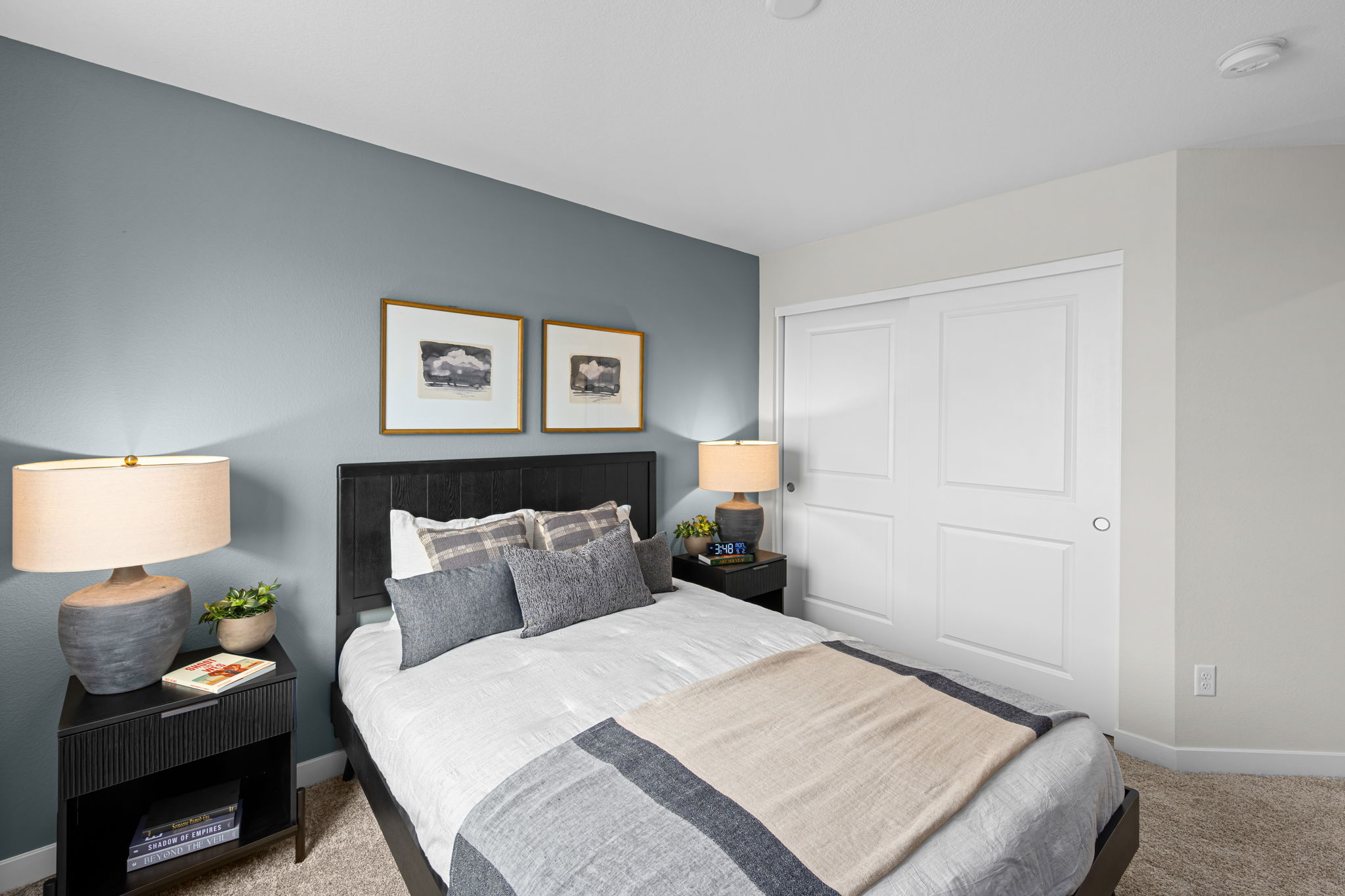 A bedroom with a bed and lamps.